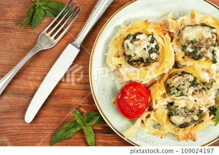Fettuccine pasta nests and meatballs. 109024197