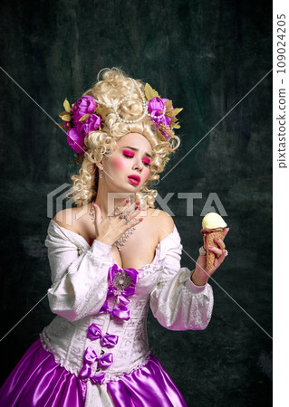 Portrait of beautiful woman, princess with bright make-up and holding cold, fresh ice cream, tasty dessert against vintage background. 109024205