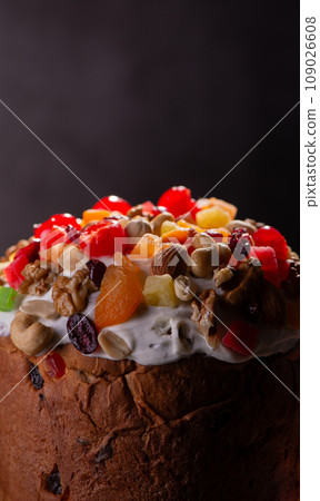 Easter Cake with dried fruits and nuts on a wooden table. Delicious traditional bakery and painted eggs for the main orthodox holiday. Easter Cake with dried fruits and nuts on a wooden table. Delicious traditional bakery and painted eggs for the main orthodox holiday. 109026608