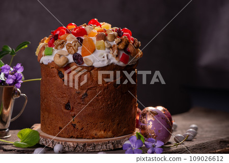 Easter Cake with fruits and nuts on a wooden table. Delicious traditional bakery and painted eggs for the main orthodox holiday.  109026612