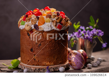 Easter Cake with dried fruits and nuts on a wooden table. Delicious traditional bakery and painted eggs for the main orthodox holiday. Easter Cake with dried fruits and nuts on a wooden table. Delicious traditional bakery and painted eggs for the main orthodox holiday. 109026614