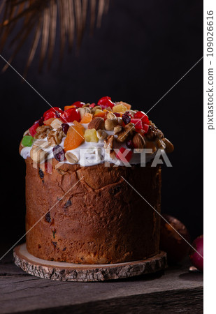 Easter Cake with dried fruits and nuts on a wooden table. Delicious traditional bakery and painted eggs for the main orthodox holiday. Easter Cake with dried fruits and nuts on a wooden table. Delicious traditional bakery and painted eggs for the main orthodox holiday. 109026616