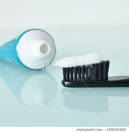 Toothbrush and toothpaste on a light blue background Toothbrush and toothpaste on a light blue background 109026898