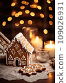 Gingerbread house on table. Defocused lights of Christmas garland. Evening in the living room. Holiday mood.  109026931