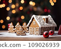 Gingerbread house on table. Defocused lights of Christmas garland. Evening in the living room. Holiday mood.  109026939