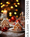 Gingerbread house on table. Defocused lights of Christmas garland. Evening in the living room. Holiday mood.  109026946