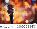 Close up of microphone in concert hall with blurred lights at background. Garland lamps or flashlights in a blurry bokeh. 109026953