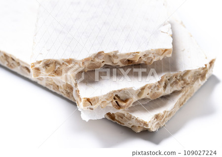 Traditional Christmas sweet, pieces of delicious almond nougat isolated on white background Traditional Christmas sweet, pieces of delicious almond nougat isolated on white background 109027224