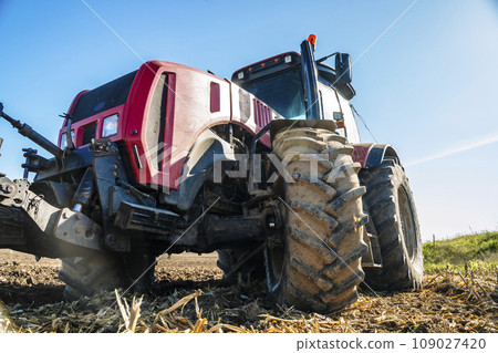 Tractor in the field. Agricultural machinery. Agricultural farm tractor during tillage of soil and field after harvest. Tractor in the field. Agricultural machinery. Agricultural farm tractor during tillage of soil and field after harvest. 109027420