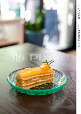 Medovik, Russian and Soviet honey cake with orange on top, served on plate 109027680