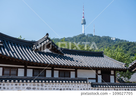 Traditional Korean building in Namsangol Hanok village, with view of N Seoul Tower or Namsan Tower in Seoul, South Korea. Traditional Korean building in Namsangol Hanok village, with view of N Seoul Tower or Namsan Tower in Seoul, South Korea. 109027705
