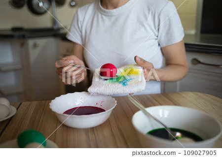 young beautiful woman in bunny ears paints eggs for easter in the kitchen young beautiful woman in bunny ears paints eggs for easter in the kitchen 109027905