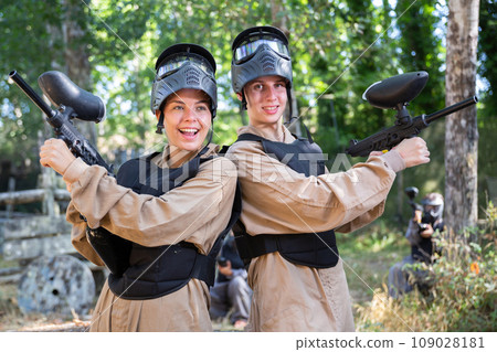 Cheerful boy and girl paintball players holding guns and posing 109028181
