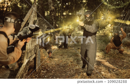 Impudent teams facing on battlefield in outdoor paintball arena during match 109028288