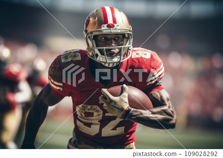 American football player of African descent in a red uniform with the ball 109028292