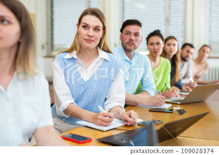 Woman university student writing in classroom 109028374