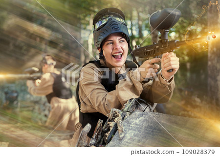 Happy girl targeting shooting with paintball marker 109028379