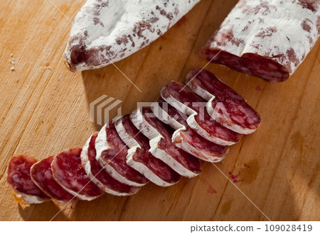 Slicing delicious Spanish smoked sausage fuete 109028419