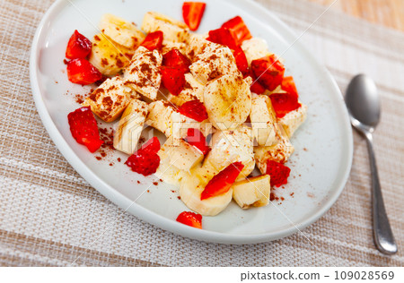 Ice cream with bananas and strawberries served on plate Ice cream with bananas and strawberries served on plate 109028569