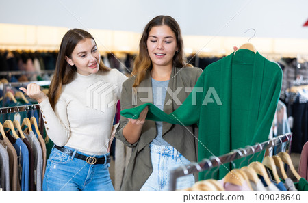 Female friends choosing warm cardigan in store 109028640