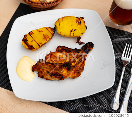 Fried chicken garnished with pieces of baked potatoes 109028645