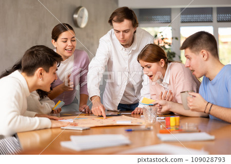 Group of students playing board game around the table 109028793