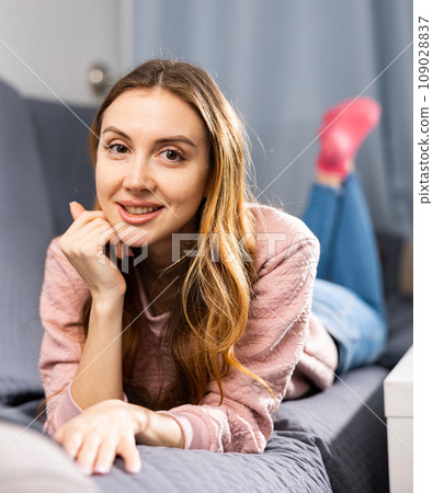 Portrait of a young woman lying on the sofa Portrait of a young woman lying on the sofa 109028837
