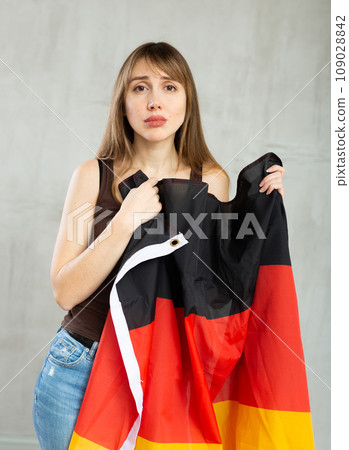 Young sad pretty woman displaying flag of germany Young sad pretty woman displaying flag of germany 109028842
