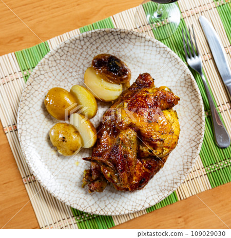 Chicken served with potatoes on platter 109029030
