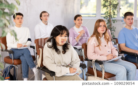 Group of high school students listening to lecture in auditorium 109029054