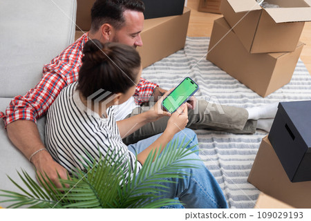 Couple chooses new things for home on website collecting necessary things with furniture with interior decoration items in boxes of different sizes for transporting things 109029193
