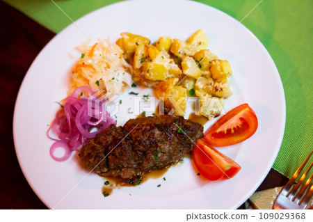 Plate with a meat dish lula-kebab and stewed potatoes. 109029368