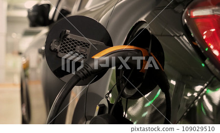 Electric Vehicle car or EV Car parking at charging station and plugged power cable supply. Charge power to EV or hybrid car battery. Green energy and eco power of World future transportation. EV power Electric Vehicle car or EV Car parking at charging station and plugged power cable supply. Charge power to EV or hybrid car battery. Green energy and eco power of World future transportation. EV power 109029510