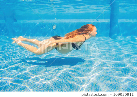 Pregnant serenity submerged a woman gracefully dives into the pool, celebrating the beauty of pregnancy with aquatic elegance 109030911