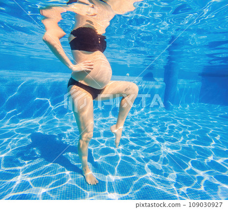 Embracing aquatic fitness, a pregnant woman demonstrates strength and serenity in underwater aerobics, creating a serene and empowering image in the pool Embracing aquatic fitness, a pregnant woman demonstrates strength and serenity in underwater aerobics, creating a serene and empowering image in the pool 109030927