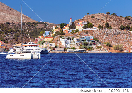 Colorful traditional multi-colored houses on the shore of the bay on Symi island. 109031138