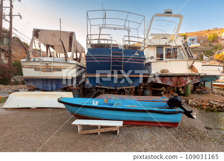 Repaired fishing boats on carts on the shore of the bay in the village of Symi. 109031165