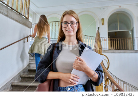 Portrait of young teenage girl student posing inside an educational building 109032423