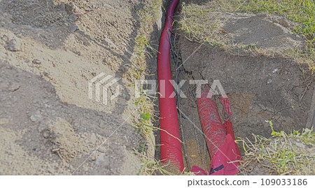Cables in the trench. High-voltage cables in a protective covering in an excavation. Concept of electrical installations, construction works, building renovations and building refurbishments 109033186