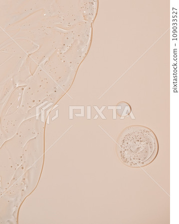 Abstract face serum texture. Skin care liquid gel on beige background. Transparent cosmetic face cream with bubbles for design. 109033527