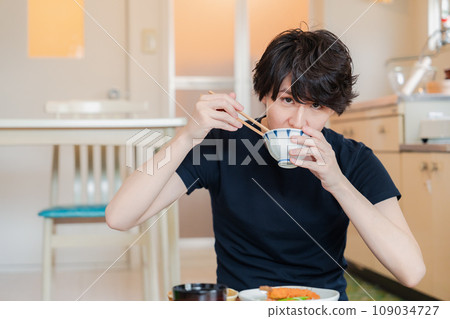 A young man eating dinner at a boarding house where he lives alone A young man eating dinner at a boarding house where he lives alone 109034727