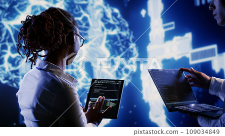 Engineering colleagues develop artificial intelligence neural networks architecture inspired by human brain, setting up AI machine learning algorithms using programming script on tablet 109034849