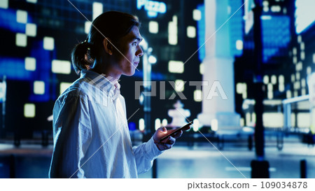 Asian man using smartphone to order cab, tired after walking many kilometers on foot around city at night. Businessman leaving work, strolling around streets, waiting for taxi Asian man using smartphone to order cab, tired after walking many kilometers on foot around city at night. Businessman leaving work, strolling around streets, waiting for taxi 109034878