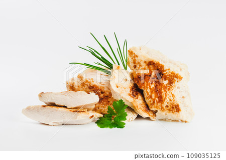 Chicken fillets fried until half cooked, semi-finished product with fresh herbs on a white background. Fast food. Quick cooking at home. Copy space.Fast cooking.Fast homemade food. 109035125
