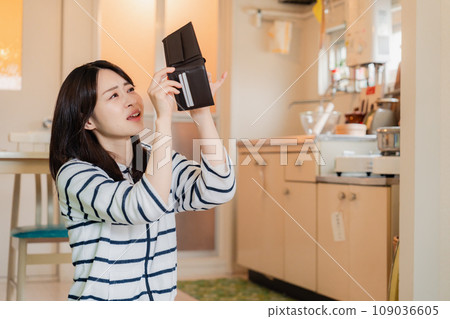 A depressed young woman checking inside her wallet 109036605