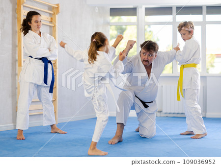Family with children training karate techniques Family with children training karate techniques 109036952