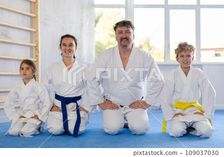 Family team of martial arts athletes is standing in gym Family team of martial arts athletes is standing in gym 109037030