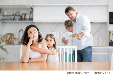 Family with two children in kitchen during quarrel 109037144