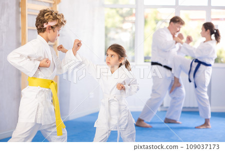 Family with child train to perform defensive karate installations and attacking combat techniques Family with child train to perform defensive karate installations and attacking combat techniques 109037173