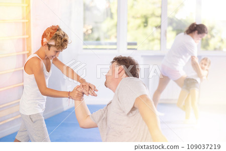 Father teaches his son to use forceful techniques and grips during self defense classes 109037219